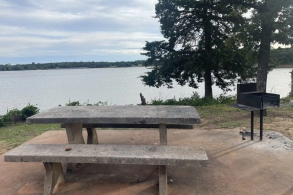 A campsite with a view of the lake at Cedar Hill State Park