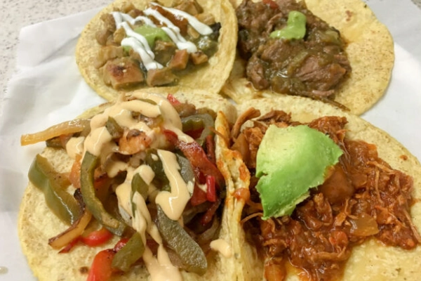 A sampler plate of stewed tacos from Guisados