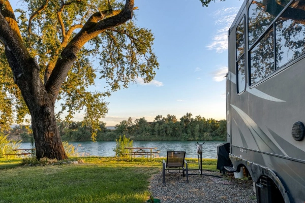An RV campsite with a view of the river at Sacramento River RV Park