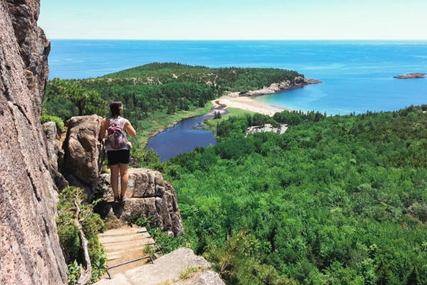 A hiker on the iron rungs of the Beehive Trail