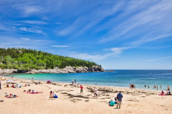 The sandy shore of Sand Beach tucked between rocky cliffs