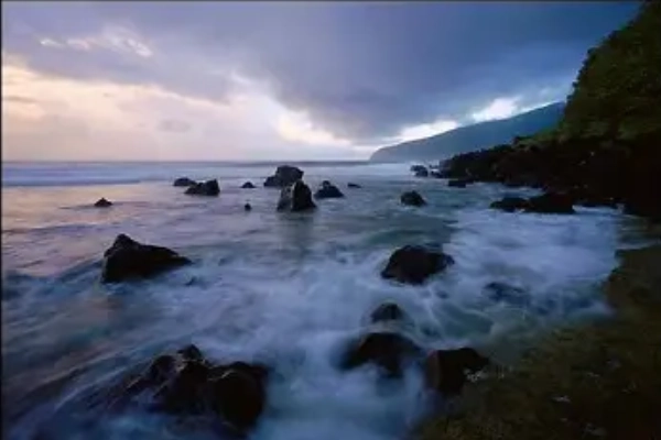 Sea cliffs with arches carved by waves at Siʻu Point