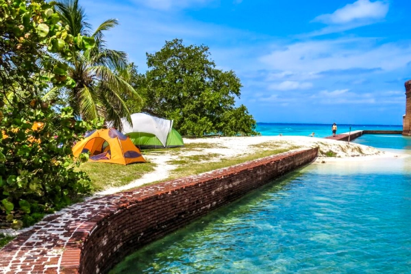 A tent pitched on the beach of Garden Key with Fort Jefferson in the background