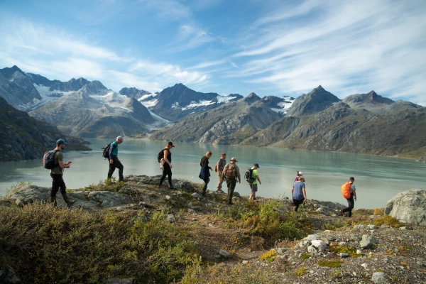 A hiker on the Lamplugh Glacier Trail with glacial erratics nearby