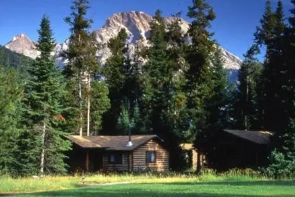 An elegant, rustic cabin at the Jenny Lake Lodge with the Teton peaks in the background