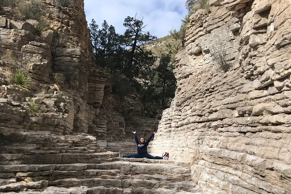 A hiker in the narrow, stony corridor of the Devil's Hall Trail