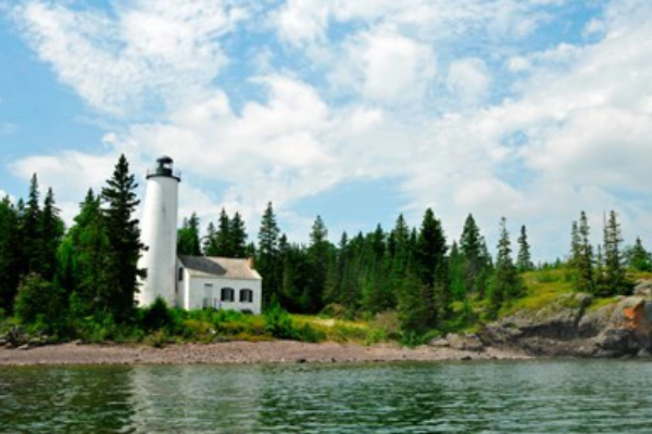 A rugged, historic lighthouse standing guard on the rocky shore of Isle Royale