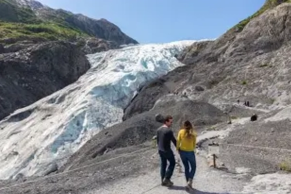 A person walking up to the face of the massive Exit Glacier