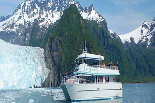 A tour boat in front of a massive glacier in Kenai Fjords