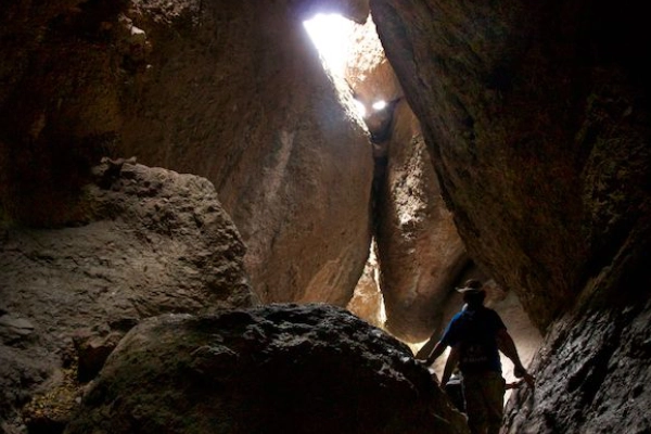 A person squeezing through a narrow passage in a natural rock maze